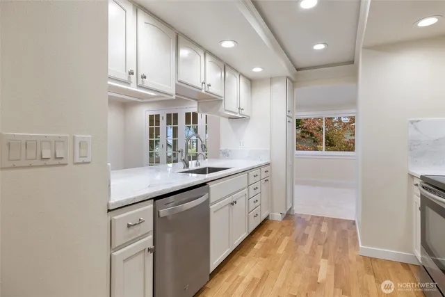 a kitchen with kitchen island granite countertop a sink and wooden cabinets