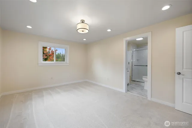 an empty room with a window and a bathroom