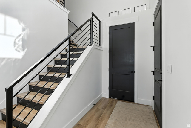 6039 North Westridge Road Heber City, UT 84032 - Photo 5 of 22 Modern interior staircase featuring wood-finish treads, contrasting black risers, and contemporary black metal railings