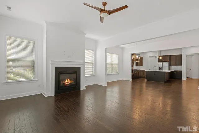 a view of empty room with fireplace and wooden floor
