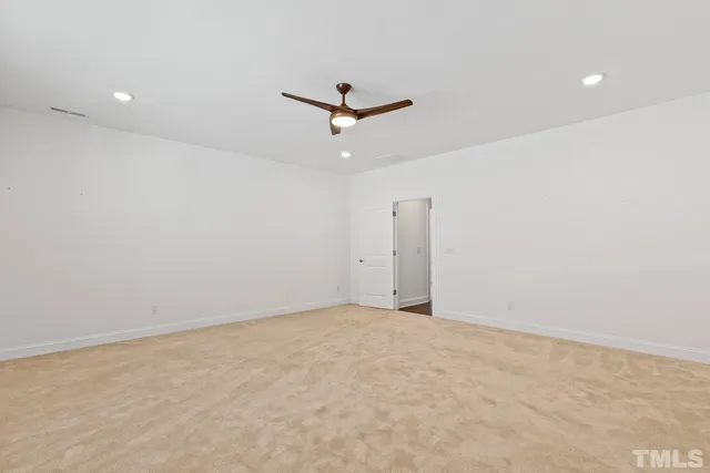 an empty room with closet and a ceiling fan
