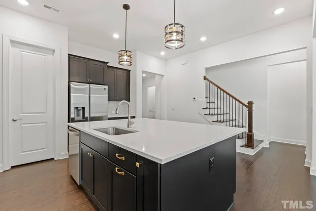a kitchen with a sink chandelier and wooden floor