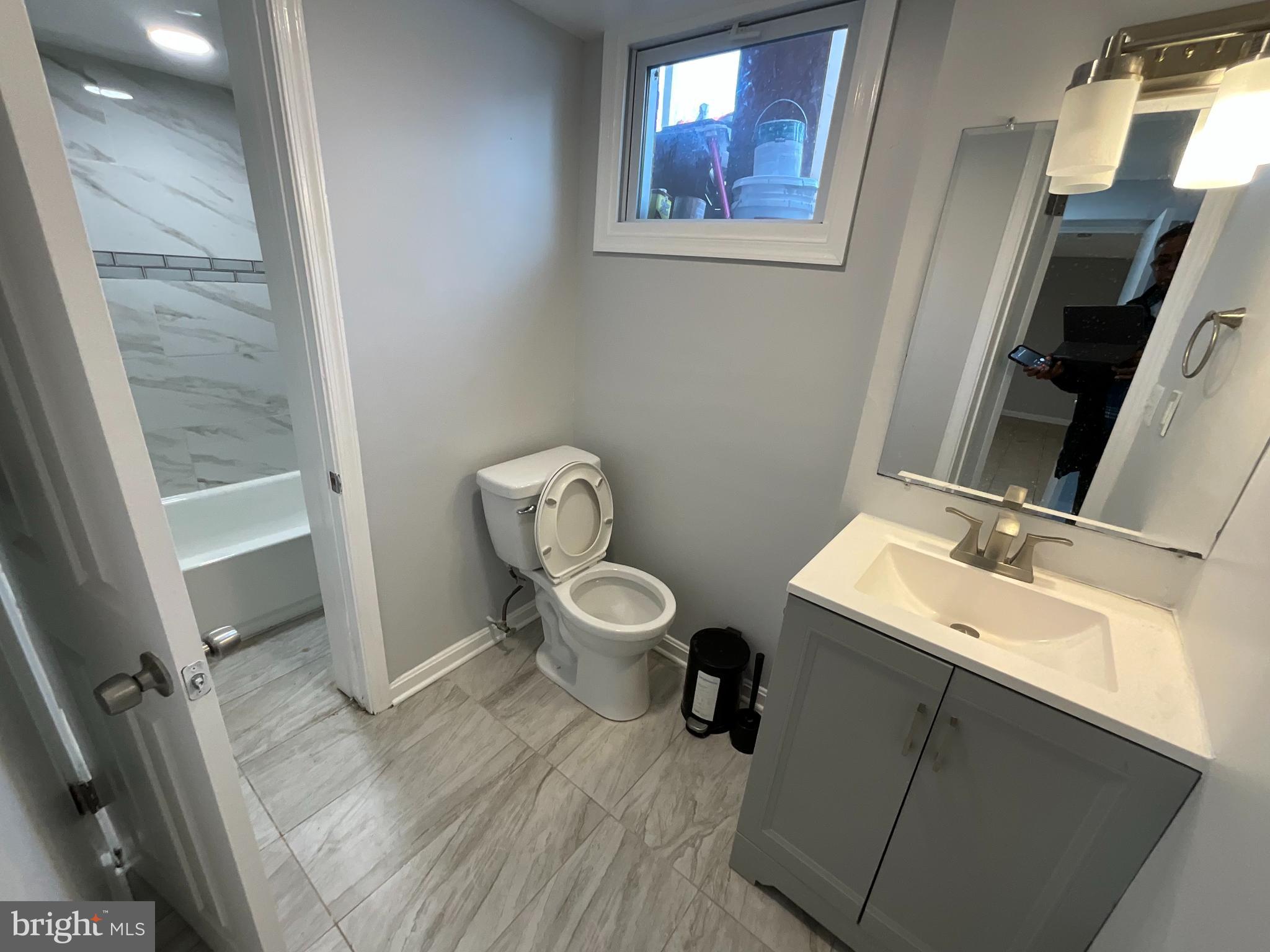 10405 Georgia Avenue Silver Spring, MD 20902 - Photo 15 of 16 a bathroom with a toilet sink and mirror