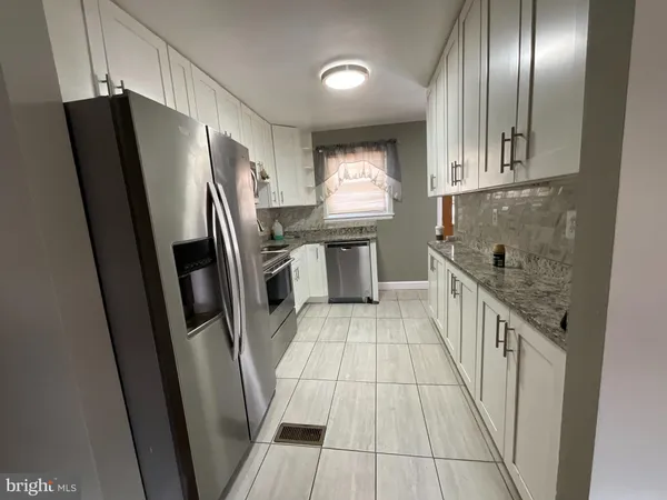 a kitchen with stainless steel appliances granite countertop a refrigerator a sink a stove and island