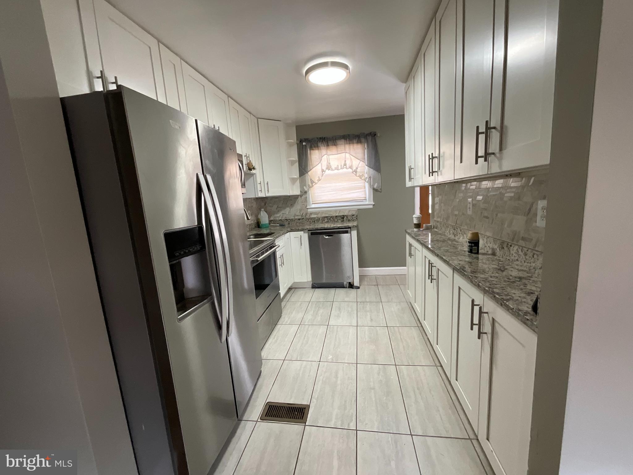 10405 Georgia Avenue Silver Spring, MD 20902 - Photo 6 of 16 a kitchen with stainless steel appliances granite countertop a refrigerator a sink a stove and island