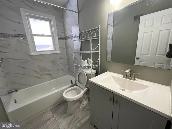 a bathroom with a sink a toilet and bathtub