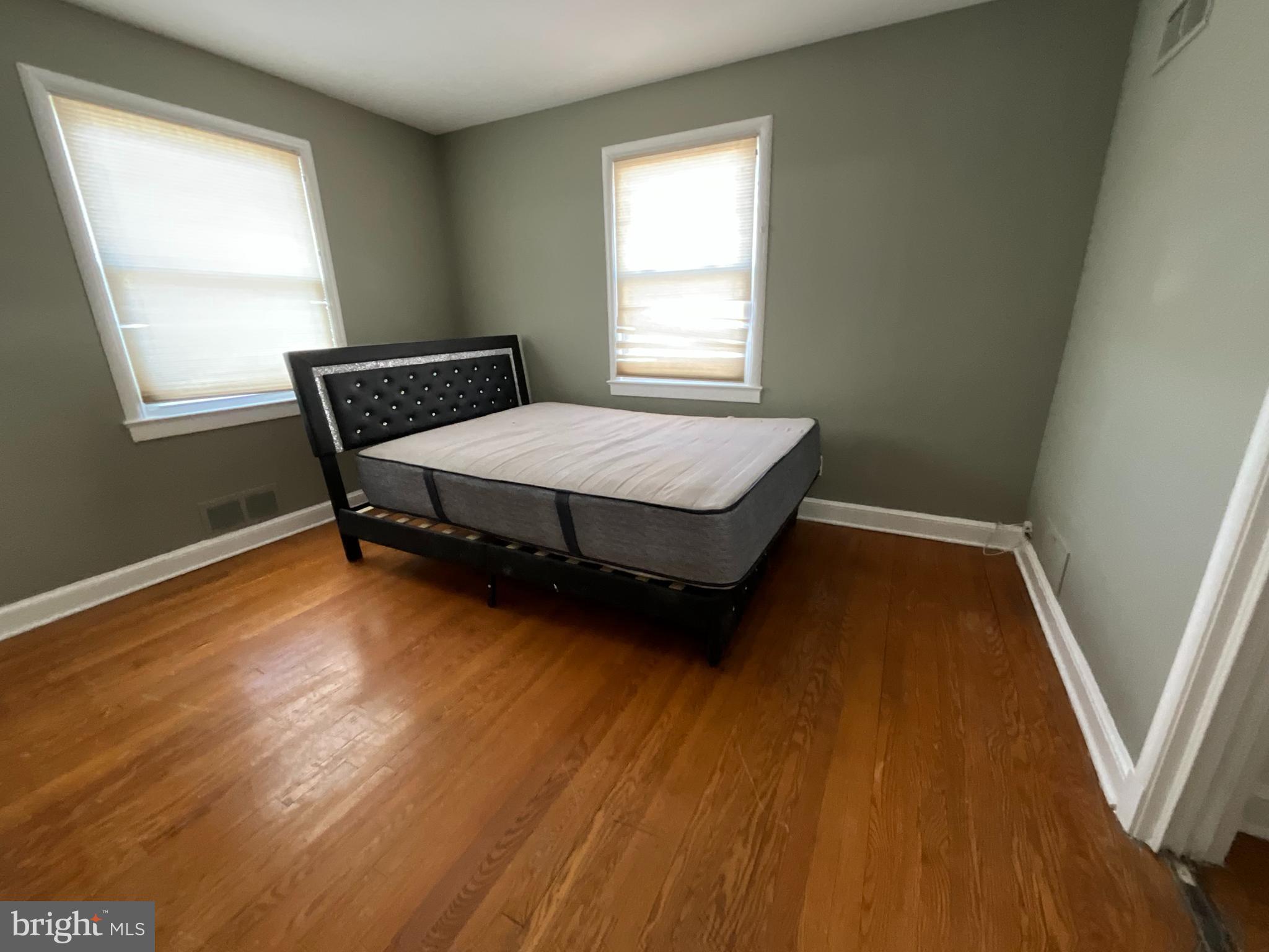 10405 Georgia Avenue Silver Spring, MD 20902 - Photo 10 of 16 a room with wooden floors and bed