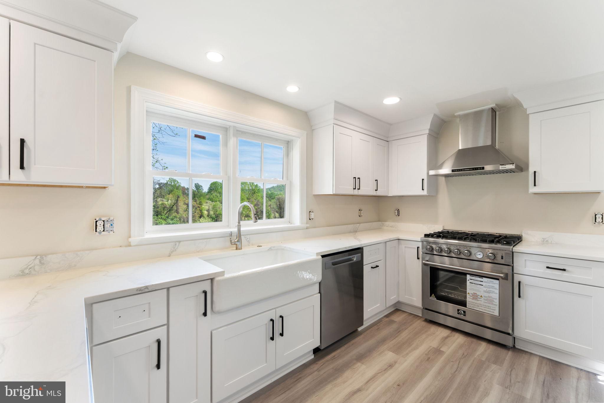 11066 Moreland Road Delaplane, VA 20144 - Photo 36 of 87 a kitchen with a sink white cabinets stainless steel appliances and a window