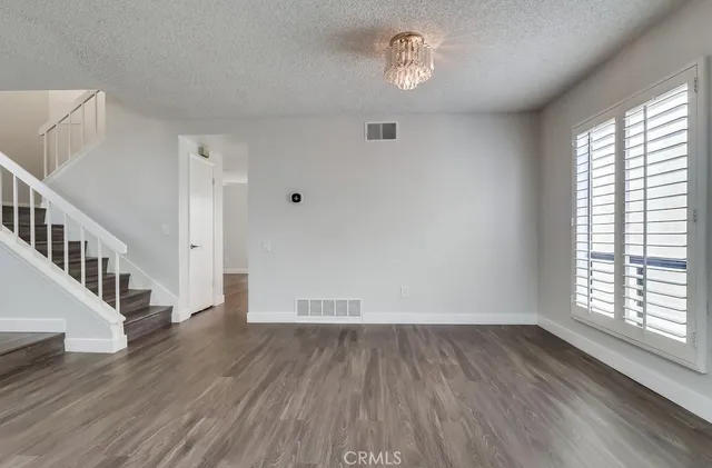 a view of a big room with wooden floor and windows