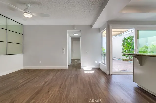 a kitchen with granite countertop white cabinets and wooden floors