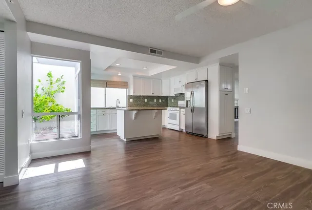 a kitchen with granite countertop white cabinets and white appliances