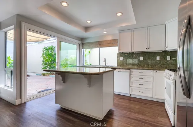 a kitchen with white cabinets and refrigerator