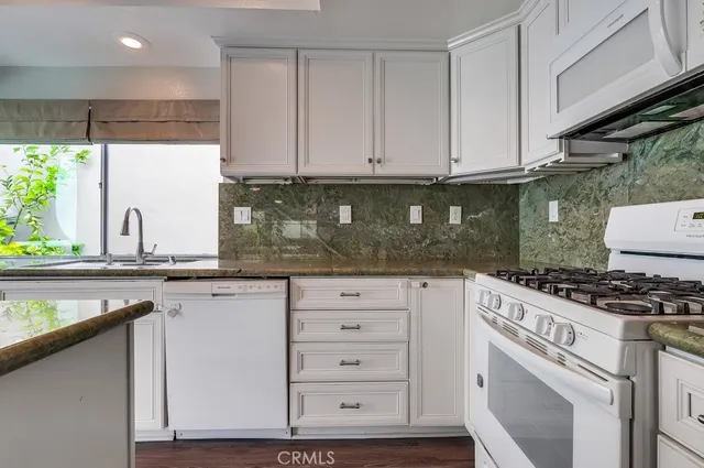 a bathroom with a granite countertop toilet sink and mirror