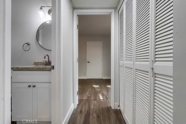 an empty room with wooden floor chandelier and windows