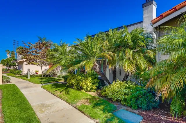a view of an entryway with wooden floor leading to a furnished livingroom and windows