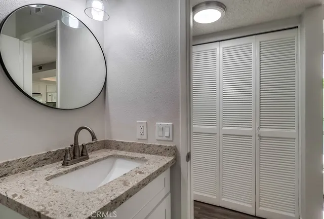 a bathroom with a granite countertop double vanity sink and a mirror
