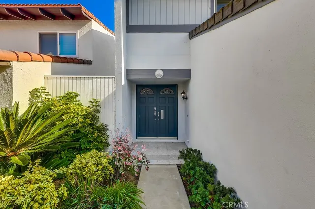 an empty room with wooden floor chandelier and windows