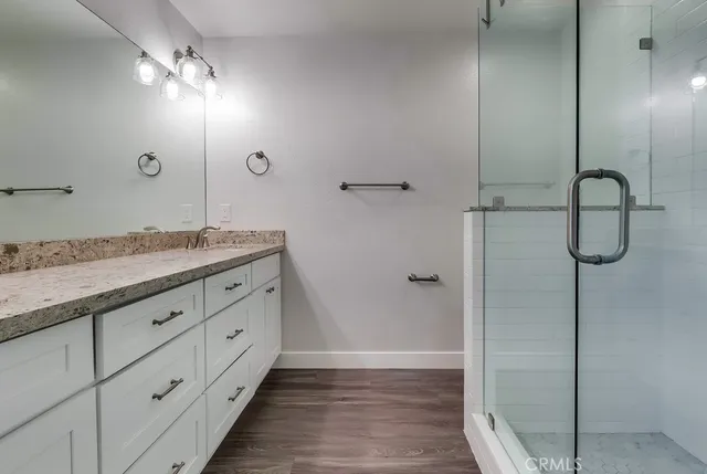 a bathroom with a granite countertop sink toilet and shower