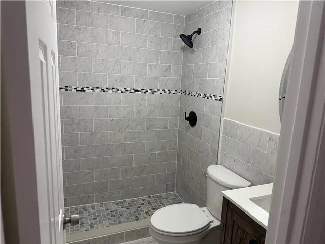 a bathroom with a shower a toilet and sink