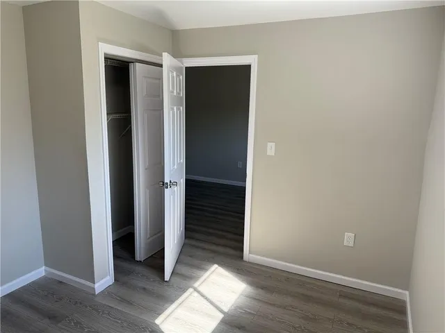 an empty room with wooden floor and closet