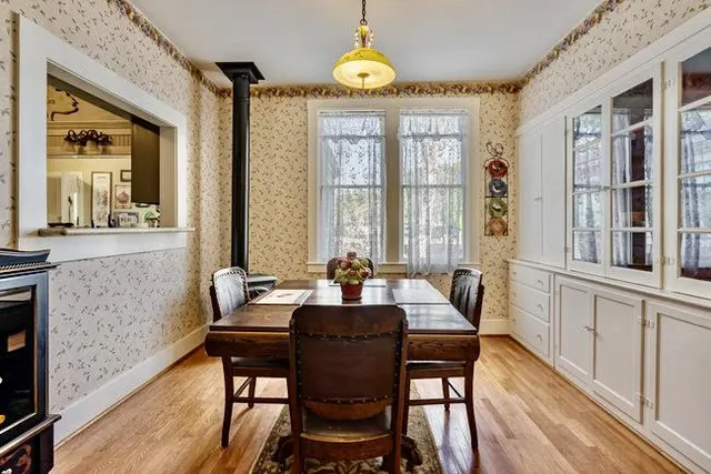a dining room with furniture a chandelier and wooden floor