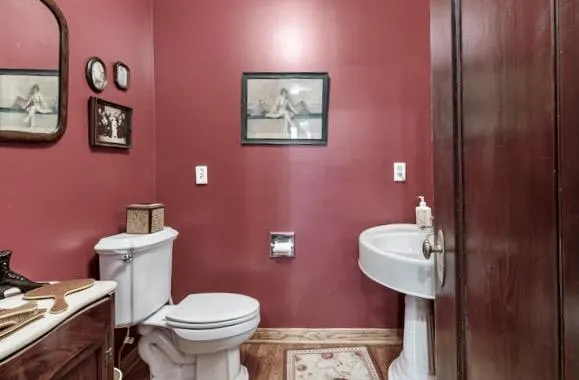 a bathroom with a toilet a sink and mirror