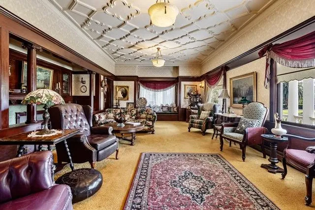 a living room with furniture kitchen view and a large window