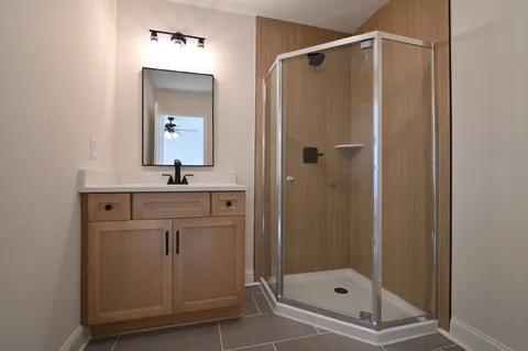 a bathroom with a shower sink and mirror