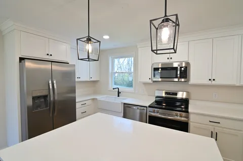 a kitchen with stainless steel appliances a refrigerator sink and stove