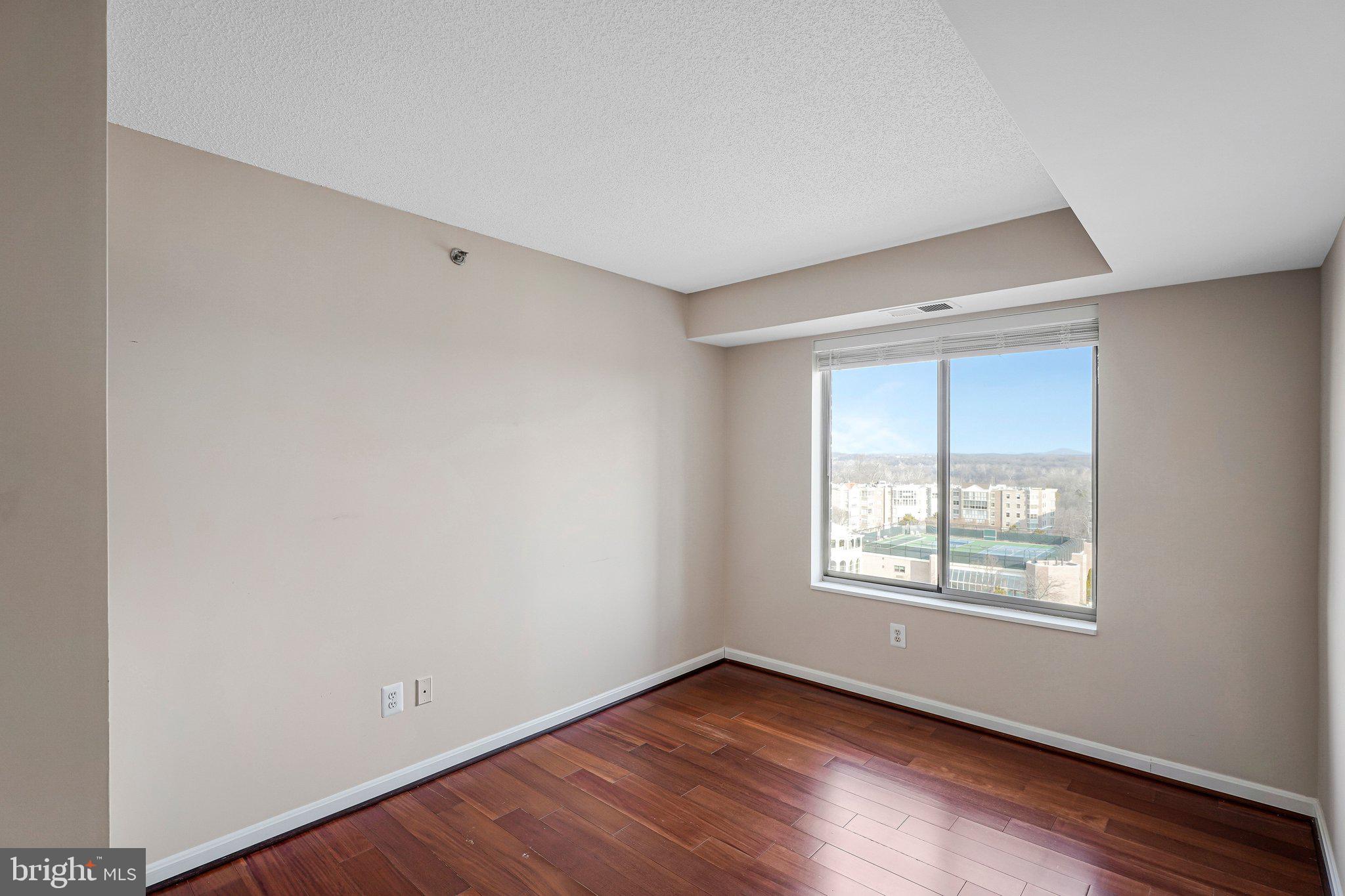 19385 Cypress Ridge Terrace, Unit 815 Leesburg, VA 20176 - Photo 14 of 35 an empty room with wooden floor and windows