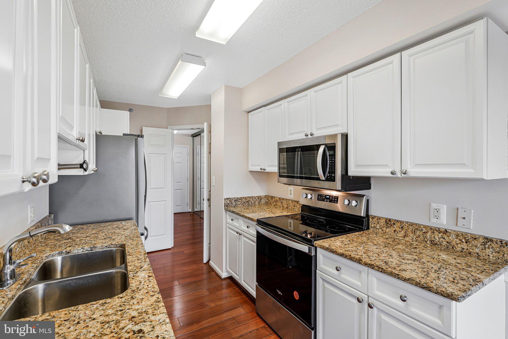 19385 Cypress Ridge Terrace, Unit 815 Leesburg, VA 20176 - Photo 8 of 35 a kitchen with stainless steel appliances granite countertop a stove refrigerator and a sink