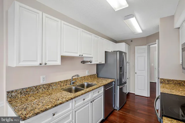 a kitchen with stainless steel appliances granite countertop a refrigerator sink and cabinets