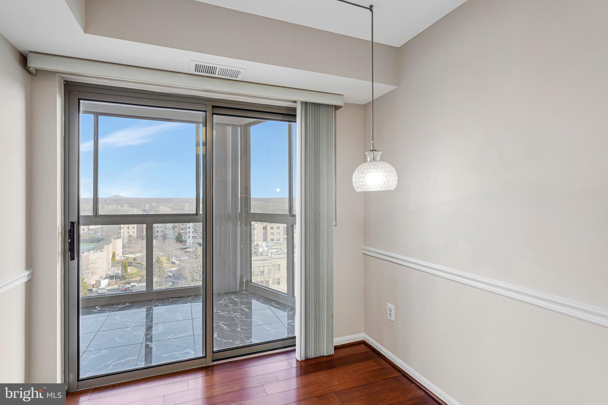 19385 Cypress Ridge Terrace, Unit 815 Leesburg, VA 20176 - Photo 10 of 35 a view of an empty room with wooden floor and a window