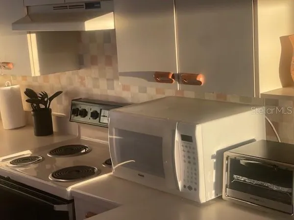 a kitchen with a sink and a stove next to a window