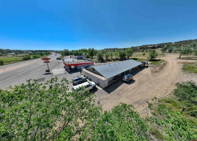 a view of a grassy area with mountains and a houses