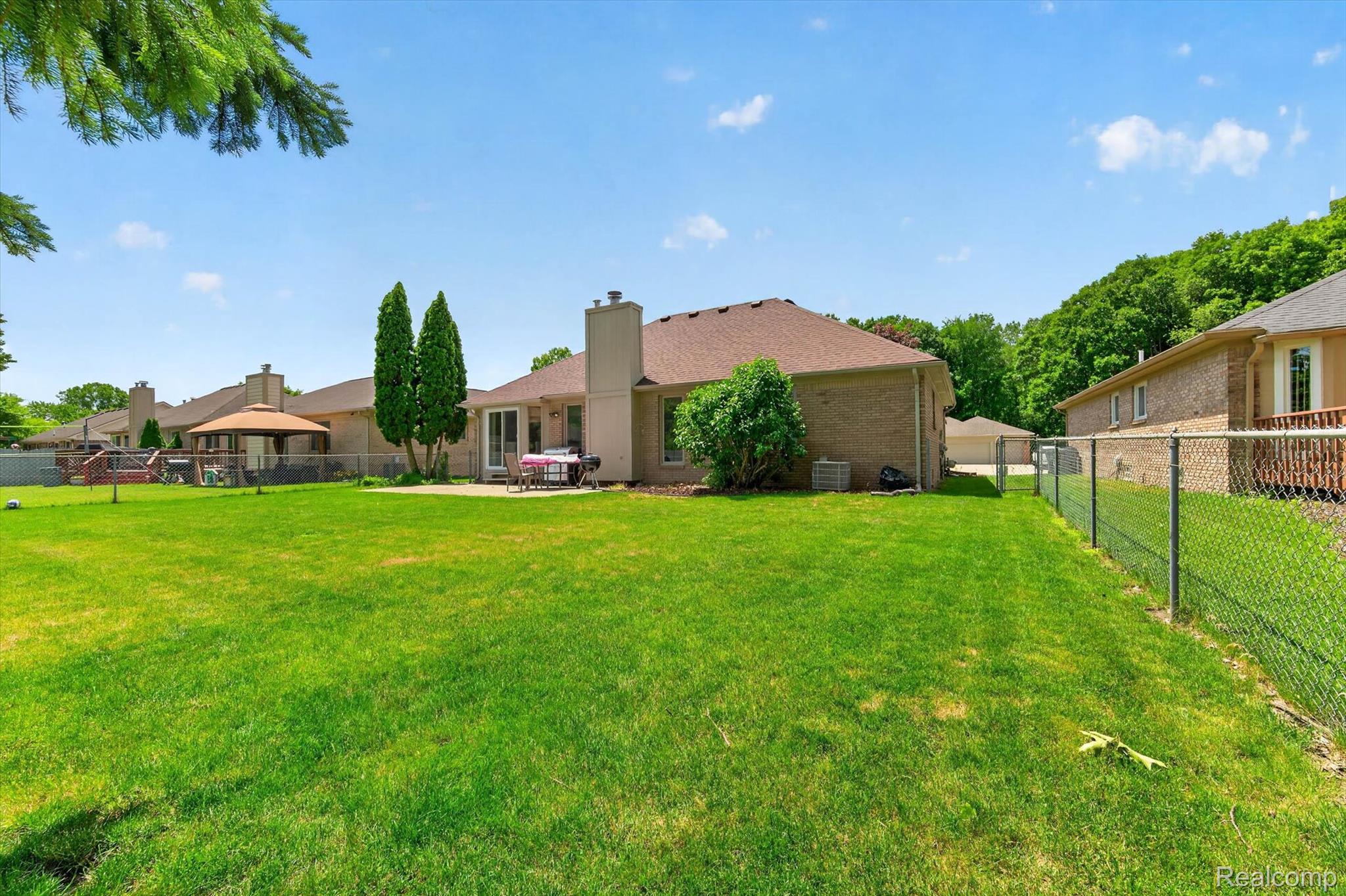 46362 Springhill Drive Utica, MI 48317 - Photo 44 of 59 Expansive green lawn with a chain-link perimeter fence