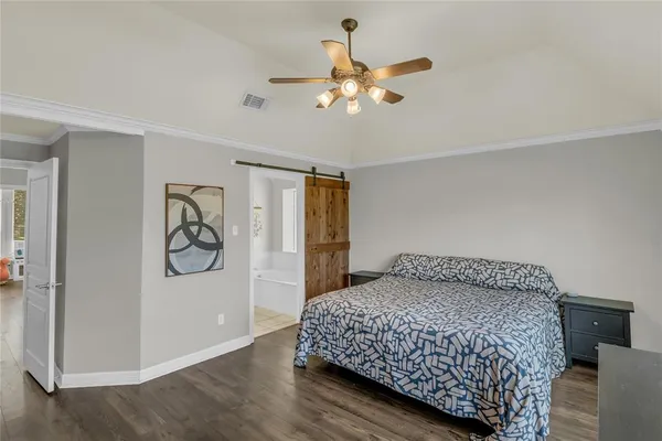 a bedroom with a large bed and a chandelier