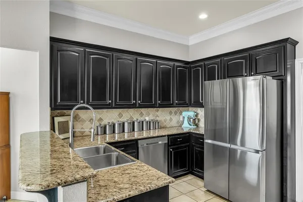 a kitchen with granite countertop a refrigerator and a sink