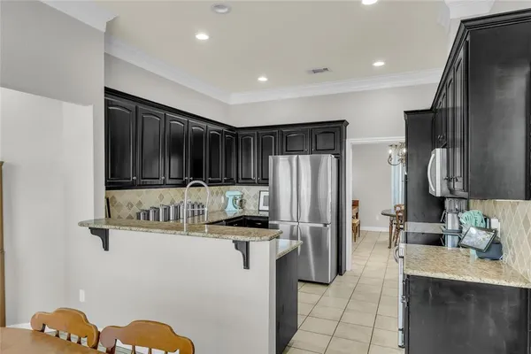 a kitchen with stainless steel appliances granite countertop a refrigerator and a sink