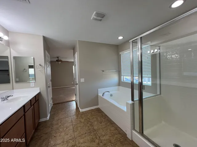 a bathroom with a tub a sink shower and mirror
