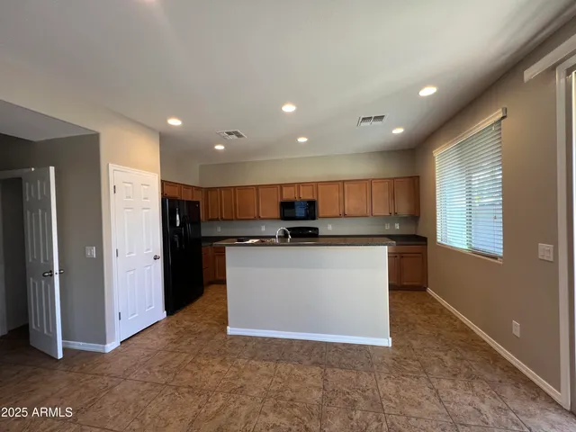 a view of kitchen with stainless steel appliances granite countertop a refrigerator and a sink