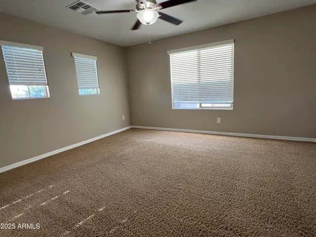an empty room with a window and a ceiling fan