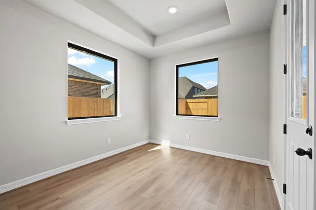 an empty room with a window and wooden floor