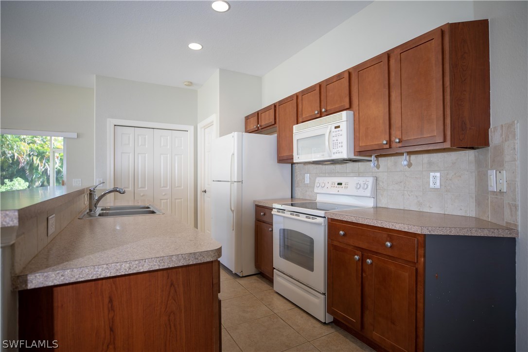 12722 River Road Fort Myers, FL 33905 - Photo 7 of 18 a kitchen with stainless steel appliances granite countertop a sink a stove and a refrigerator