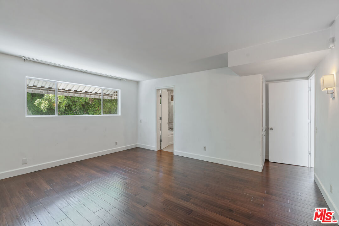 603 North Doheny Drive, Unit 2B Beverly Hills, CA 90210 - Photo 12 of 21 an empty room with wooden floor and windows
