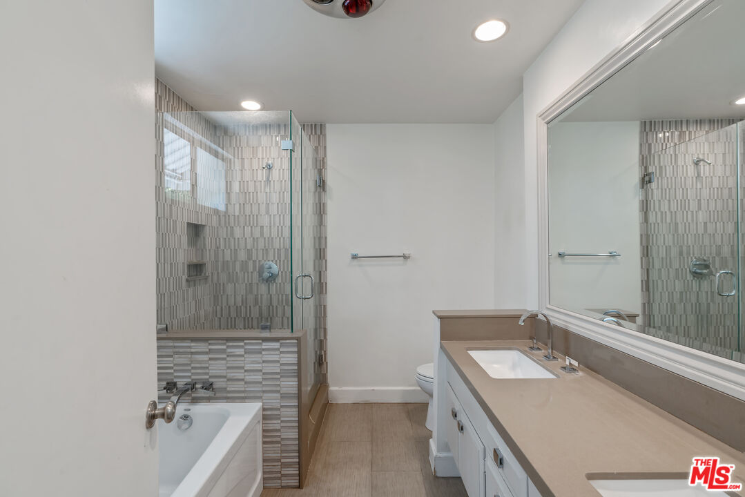603 North Doheny Drive, Unit 2B Beverly Hills, CA 90210 - Photo 13 of 21 a bathroom with a tub sink vanity granite and shower