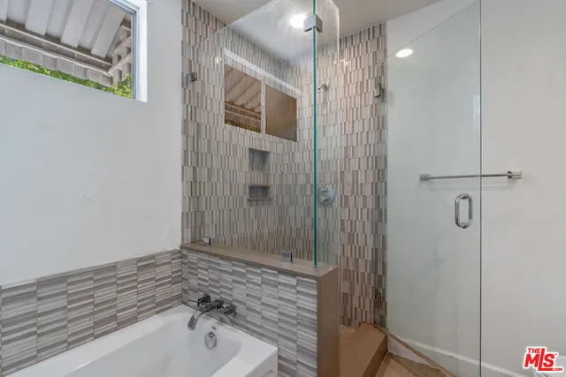 a bathroom with a bathtub and shower