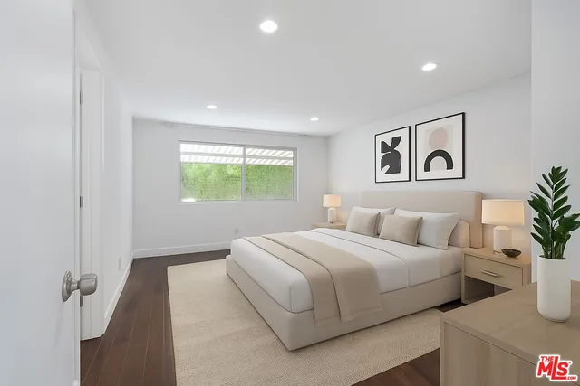 a bedroom with a large bed and a potted plant