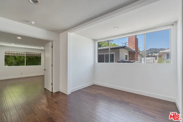 a view of a big room with wooden floor and windows