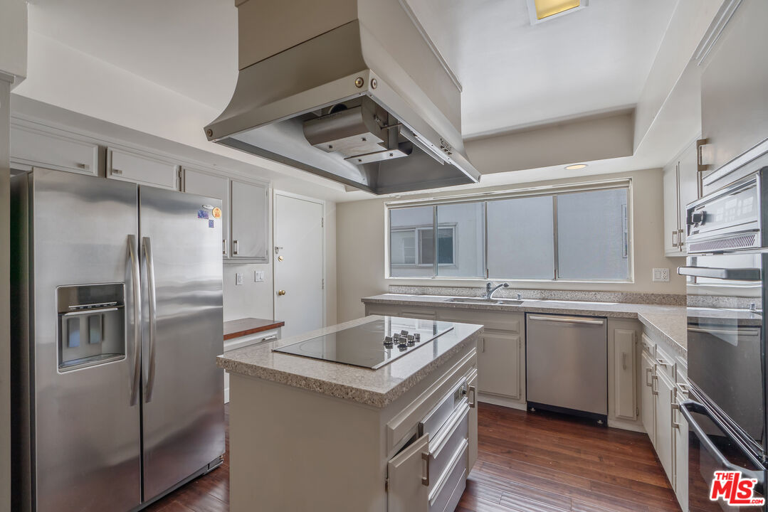 603 North Doheny Drive, Unit 2B Beverly Hills, CA 90210 - Photo 8 of 21 a kitchen with stainless steel appliances granite countertop a sink stove and refrigerator